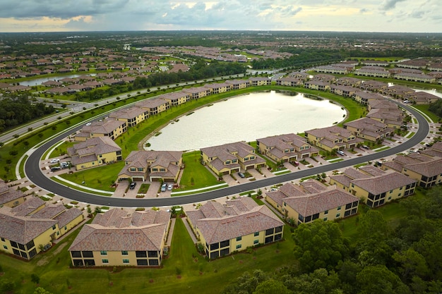 View from above of densely built residential houses near retention ponds in closed living clubs in south Florida American dream homes as example of real estate development in US suburbs