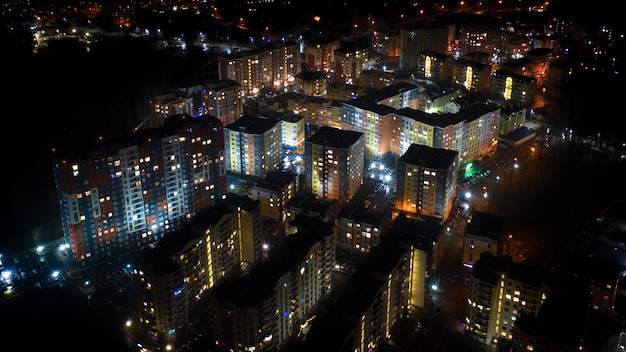 View from the drone to the night city and colored multi-storeyed buildings of the Irpin city, Kiev region, Ukraine.