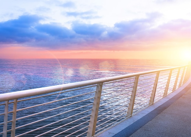 View from the embankment fence ocean during sunset sun glare