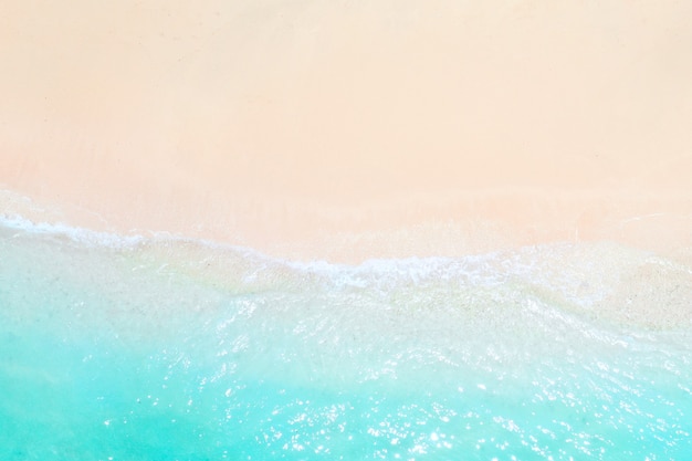 A view from a height of a Tropical beach and waves breaking on a tropical golden sandy beach. The sea waves gently wind along the beautiful sandy beach.