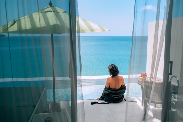 View from the hotel room of a woman sitting near the infinity pool