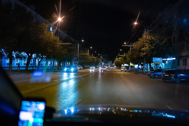 A view from inside the car driving at night in the city traffic highway