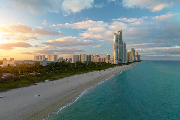 View from above of luxurious highrise hotels and condos on Atlantic ocean shore in Sunny Isles Beach city in the evening American tourism infrastructure in southern Florida