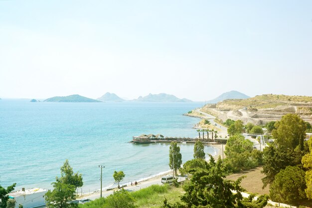 View from the mountains to the sea, palm trees and city roads on a sunny day