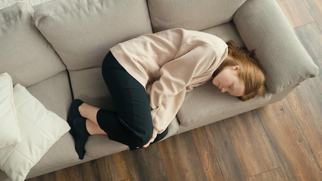 View from above a pensive redhaired girl is sad alone a depressed teenager