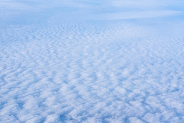 The view from the plane window of dense curly clouds and the blue stratosphere Cloudscape Blue sky and white cloud