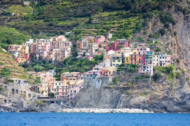 View from sea on Manarola city and beach with pier in Cinque terre Liguria Italy