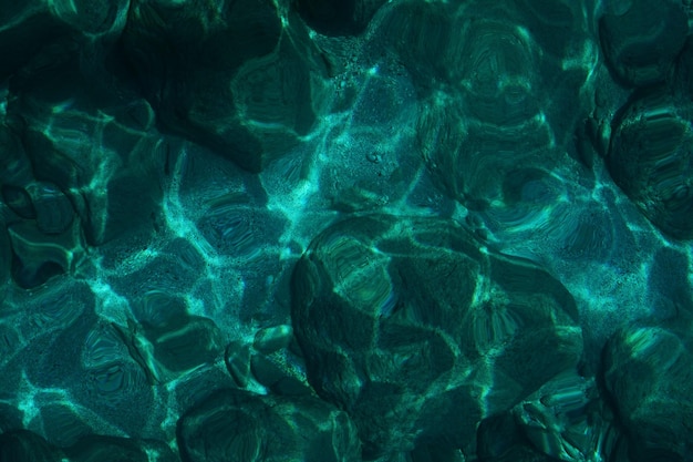 View from above to stony seabed in clear water with abstract blue green pattern