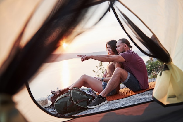 View from tent of couple lying a view of lake during hiking trip. avel Lifestyle concept adventure vacations outdoor