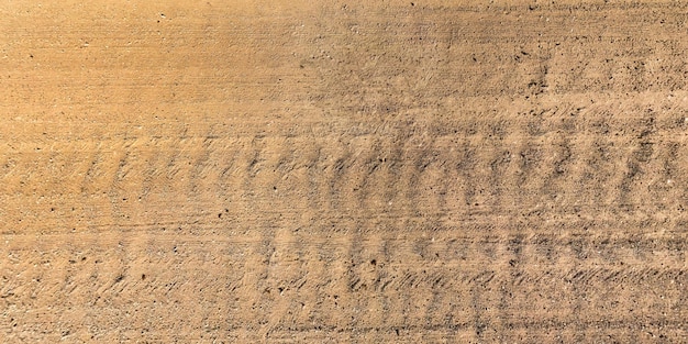 View from above on texture of gravel road with car tire tracks