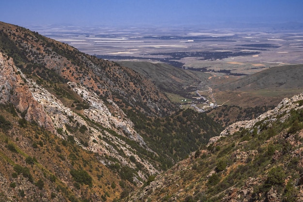 View from the top of the mountains to a rural village in a valley in Kazakhstan in summer