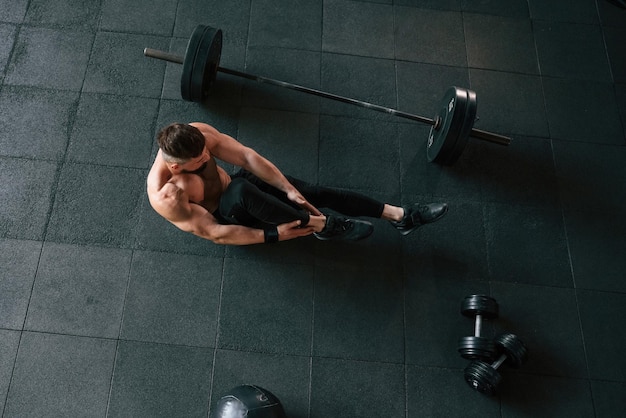 Photo view from the top strong muscular man is working out in the gym