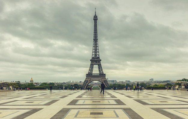 View from the Trocadero square to the eiffel tower at a cloudy day in paris, vintage colors. ideal for websites and magazines layouts