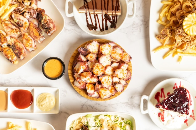 View from above of various seafood dishes such as octopus, squid and cuttlefish. Along with desserts