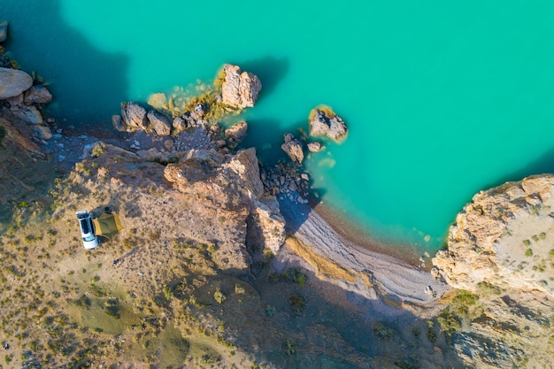 View from above, view from the air to the emerald sea with the beach and tourists by car