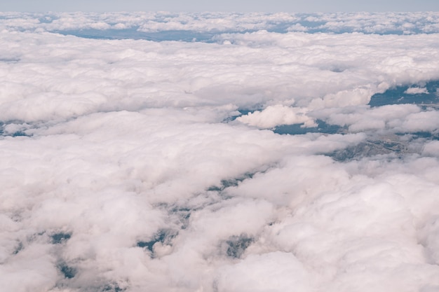 Photo view from the window of the plane on the white cumulus clouds in the sky