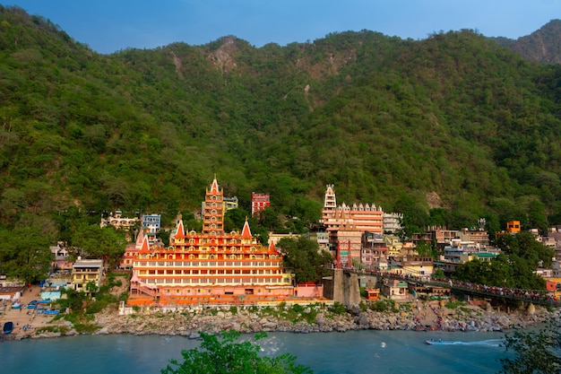 View of Ganga river embankment Lakshman Jhula bridge and Tera Manzil Temple Rishikesh India