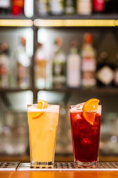 View on glass with red and yellow drink on bar Blurred background Horizontal photo