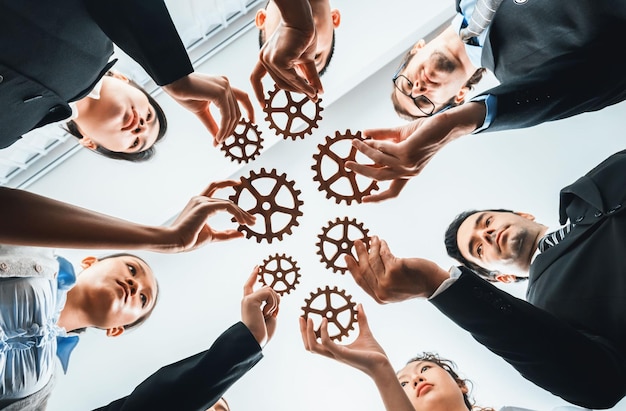 Below view group of multiracial business people joining gear wheels together as effective unity and productive teamwork concept Efficient system business team process for solution solving Habiliment