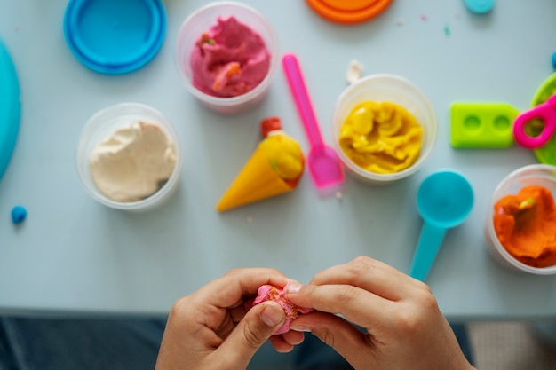 Above view hands holding pink playdough