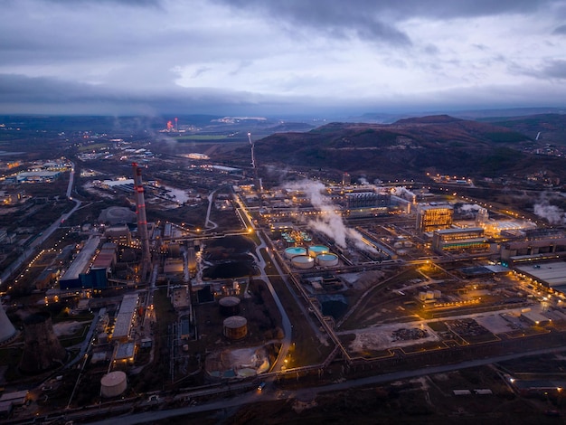 View of a heavily smoking factory at night industrial area aerial view