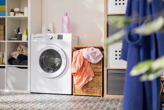 View of home laundry room dresser with detergent powder towels open washing machine