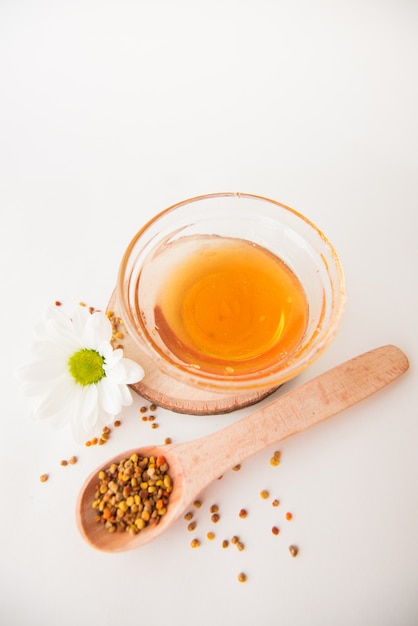 Above view of honey jar, chamomile and spoon