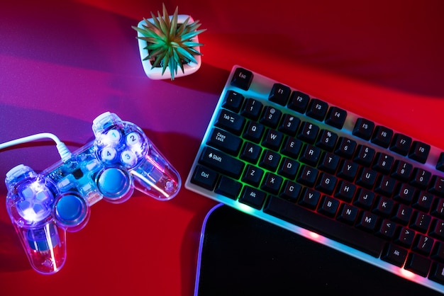 View of illuminated neon gaming keyboard setup and controller