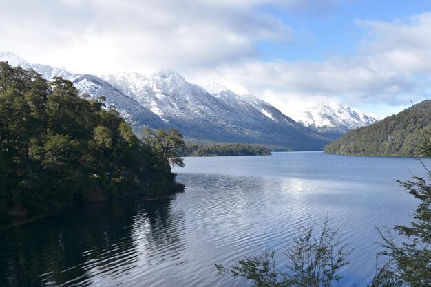 a view of a lake with snow covered mountains in the background