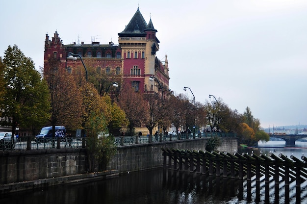 View landscape cityscape classic vintage retro antique building with trunk wooden barrage weir dam and wood barrier boat in Vltava river at Praha city on December 11 2016 in Prague Czech Republic