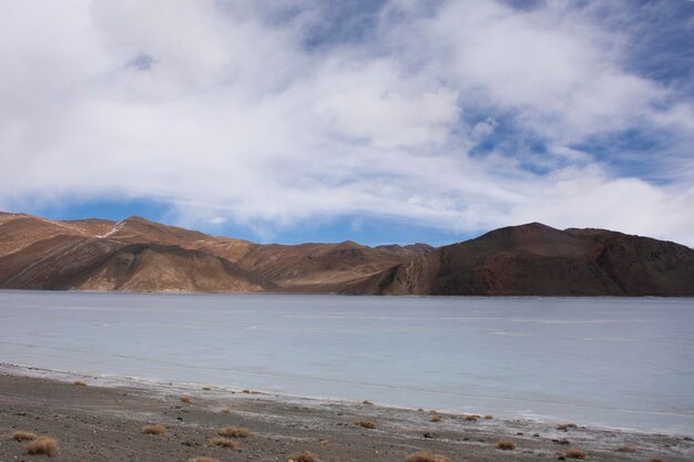 View landscape with Himalayas mountains and Pangong Tso high grassland lake while winter season for indian and tibetan and foreigner travelers travel visit at Leh Ladakh in Jammu and Kashmir India