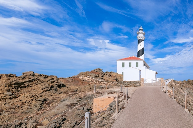 View of the lighthouse (Faro de Favaritx) in sunny weather with beautiful clouds in the sky on the island of Menorca, Balearic islands, Spain