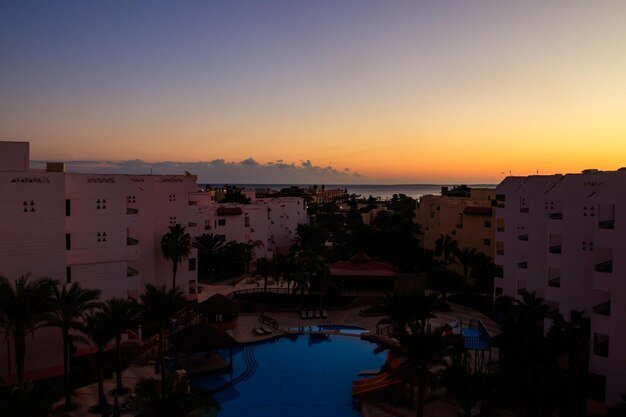 View of the luxurious hotel with a swimming pool and Red sea at sunrise