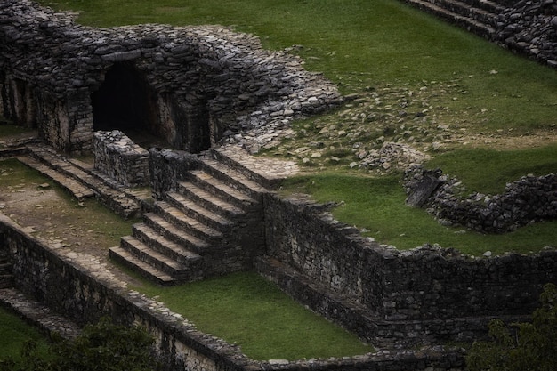 View of medieval old rocky stairs between green grassland floors in the forest