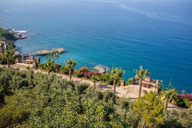 A view of the Mediterranean coast with waves of azure water. Summer seascape. Seaside in sunny weather. Beautiful sea view