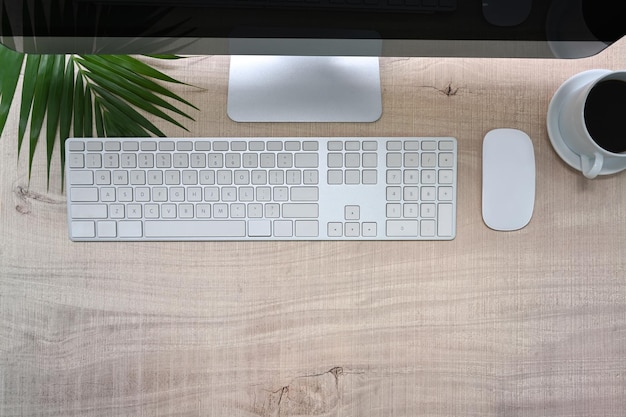 Above view modern workspace with computer and coffee cup on wooden desk