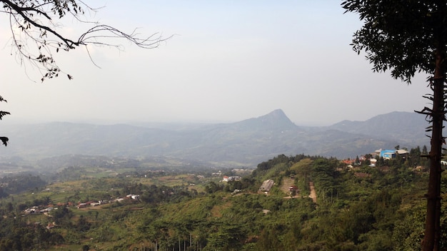 View of a mountain covered in mist and clear clouds