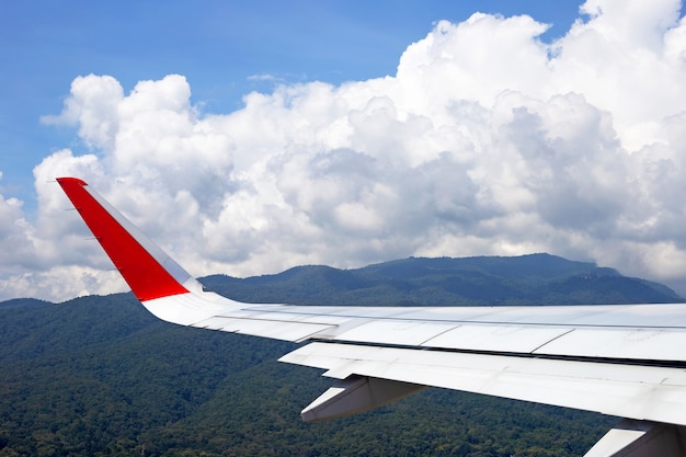 View of mountain, sky, cloud and wing of airplane from window