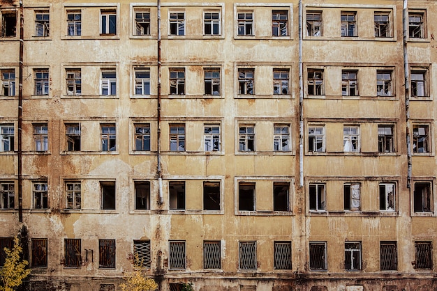 View of a multi-storey abandoned house with broken windows.