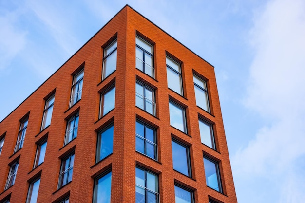 View of a new residential rectangular modern red brick house with classic windows