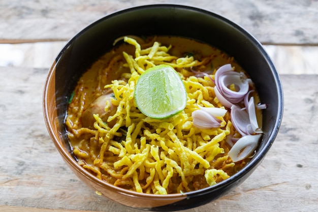 View of Noodle with curry soup and chicken (Khao Soi) food of Northern Thailand traditional 