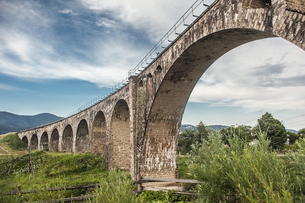 A view to the old viaduct bridge in the mountains. Travel, discover, nature, architecture concept