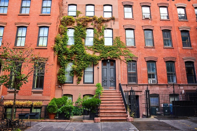 View outside beautiful apartment building with red bricks and green vines in Greenwich Village New Y