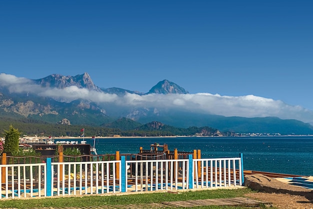 View of the path and the bridge in a green garden with green trees along the embankment in Kemer Turkey