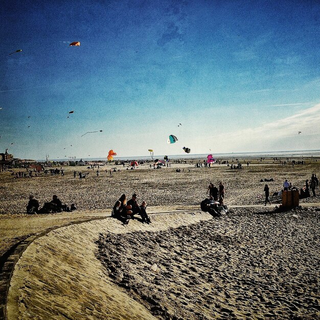 Photo view of people with kites on beach