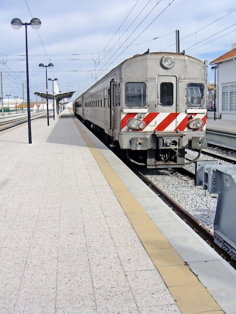 View of a portuguese train stopped at a train station.