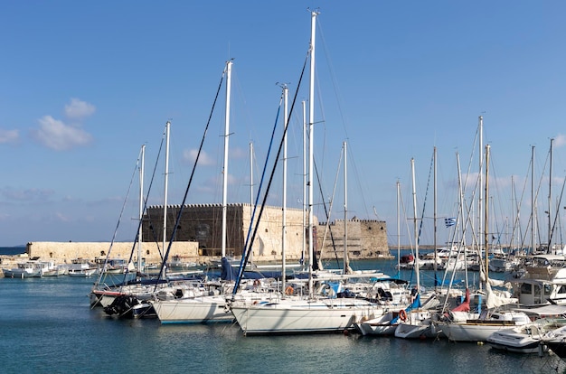 View of the quay the Venetian fortress and the moored boats and yachts city Heraklion island Crete Greece