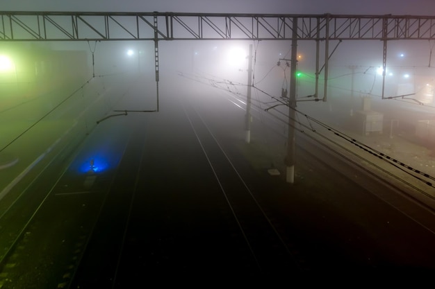 View of the railway from the bridge at night in the fog