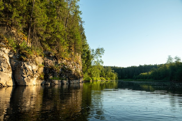 View of the river and a beautiful cliff illuminated by the sun during rafting on the river in summer Perfect river landscape