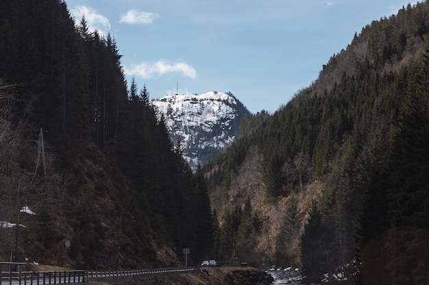 View of a river with a snowcapped mountain in the background between two other mountains